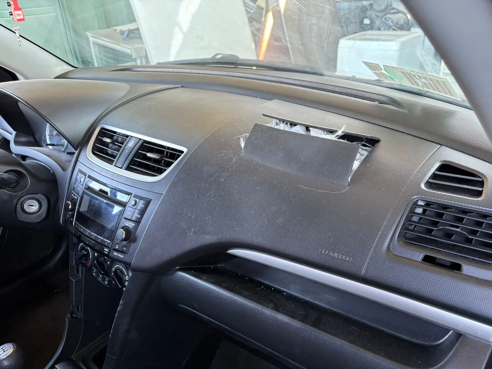 Airbag de acompañante abierto en tablero de Suzuki Swift listo para reparar