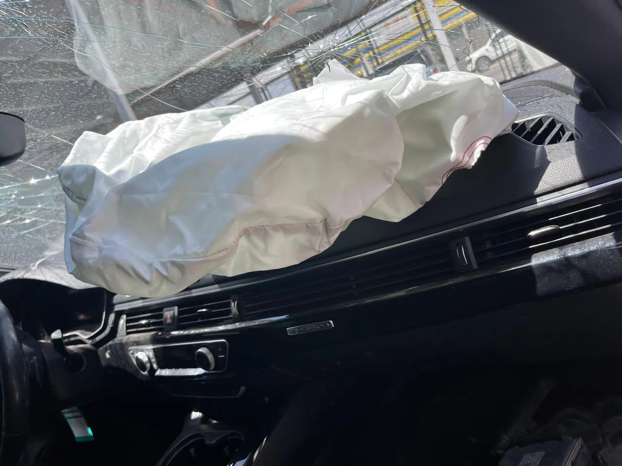 Airbag de pasajero desplegado en Audi con parabrisas fracturado tras colisión