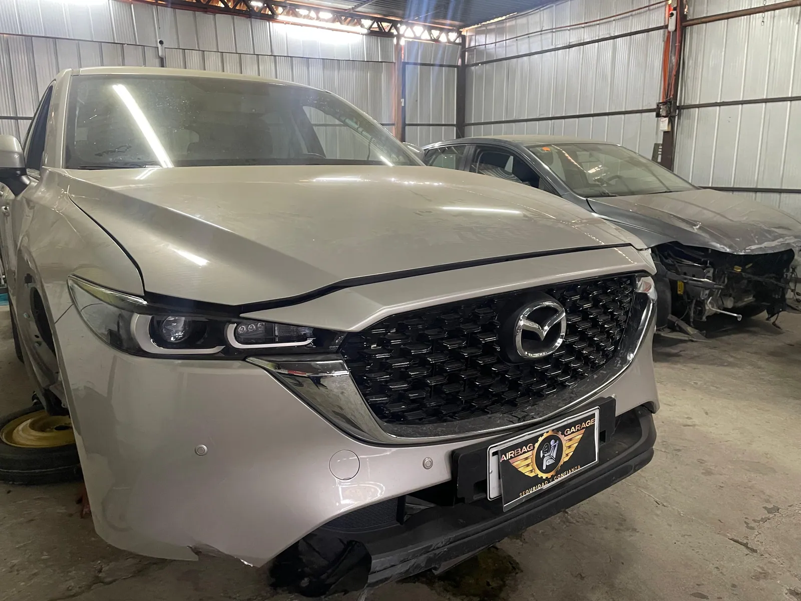 Mazda CX-5 en taller de reparación de airbags comparando antes y después